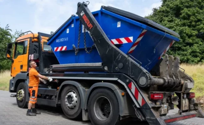 Mitarbeiter der HUI vor einem Absetzkipperfahrzeug